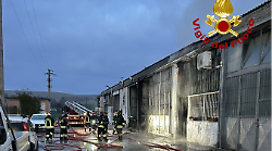 Vigili del fuoco impegnati a domare l'incendio di un capannone