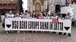 Lavoratori Beko espongono lo striscione alle Strade Bianche