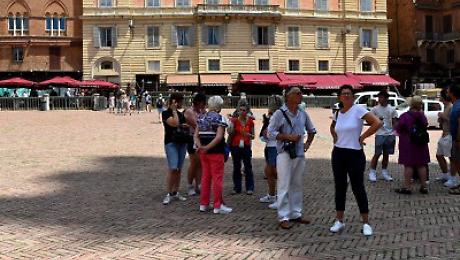 Turisti all'ombra in Piazza del Campo